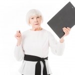 Seriöse Senior-Geschäftsfrau mit Klemmbrett und Stift isoliert auf weiß