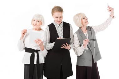 Dijital tablet, Pano ve üzerinde beyaz izole smartphone ile üç şık iş kadınları