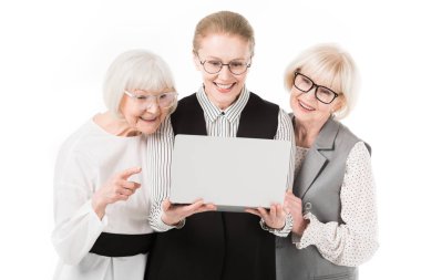 Üç şık iş kadınları üzerinde beyaz izole dizüstü bakarak gözlük