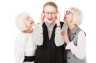 Mature stylish businesswoman shutting ears between two senior businesswomen in eyeglasses isolated on white clipart