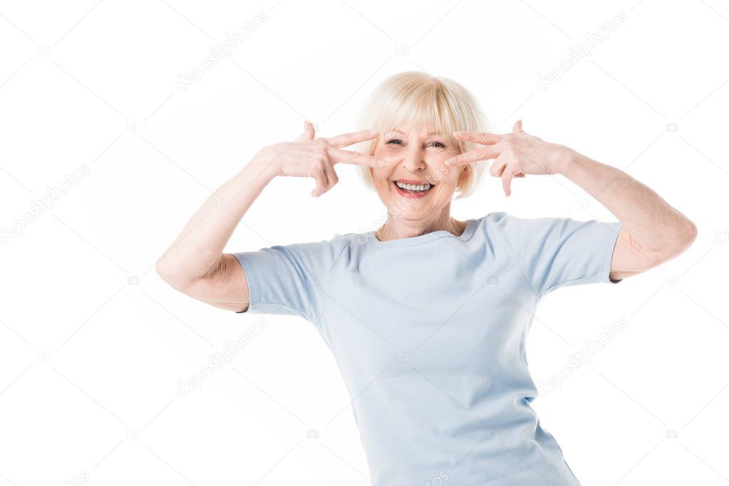 Smiling senior woman gesturing with fingers isolated on white