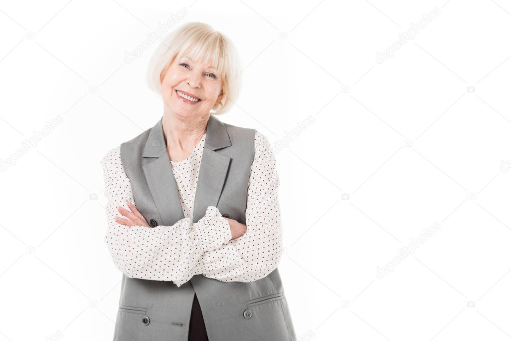 Portrait of smiling senior businesswoman with crossed arms isolated on white