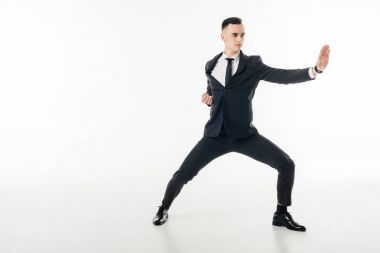 yakışıklı işadamı beyaz izole takım elbiseli karate pozisyonda ayakta