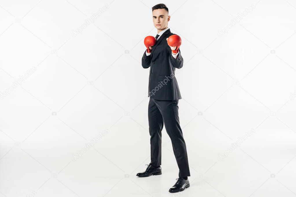 businessman in suit and red gloves looking at camera isolated on white
