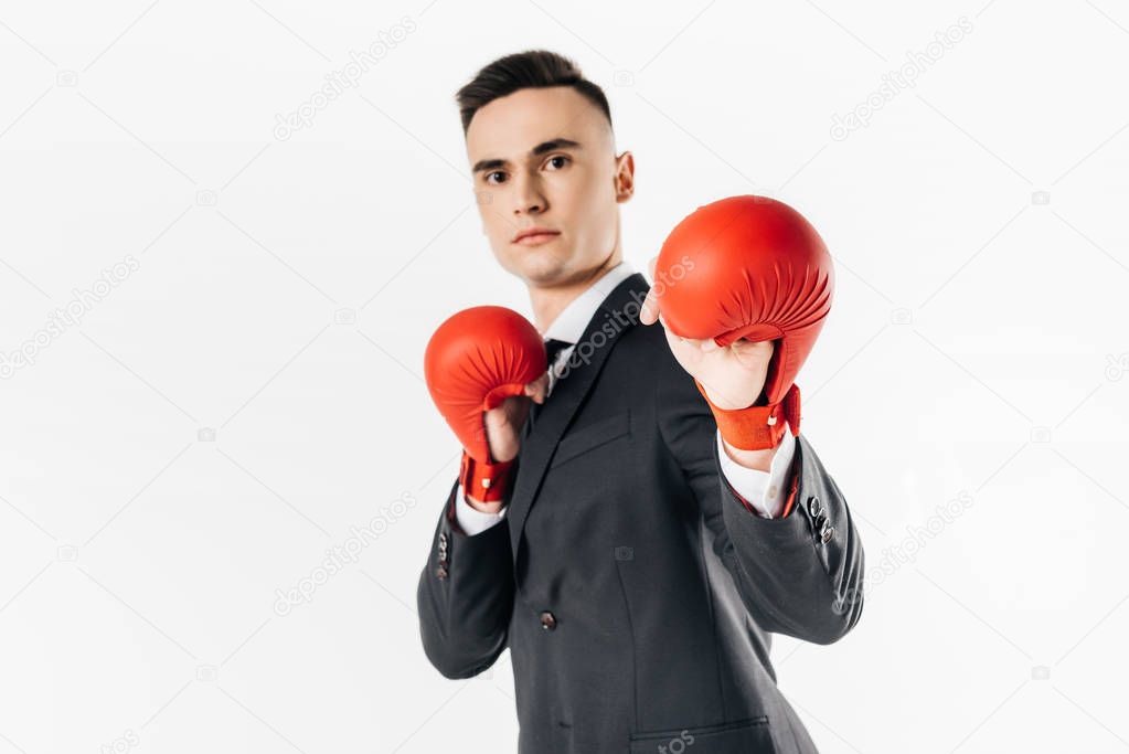 businessman in suit and red gloves looking at camera isolated on white