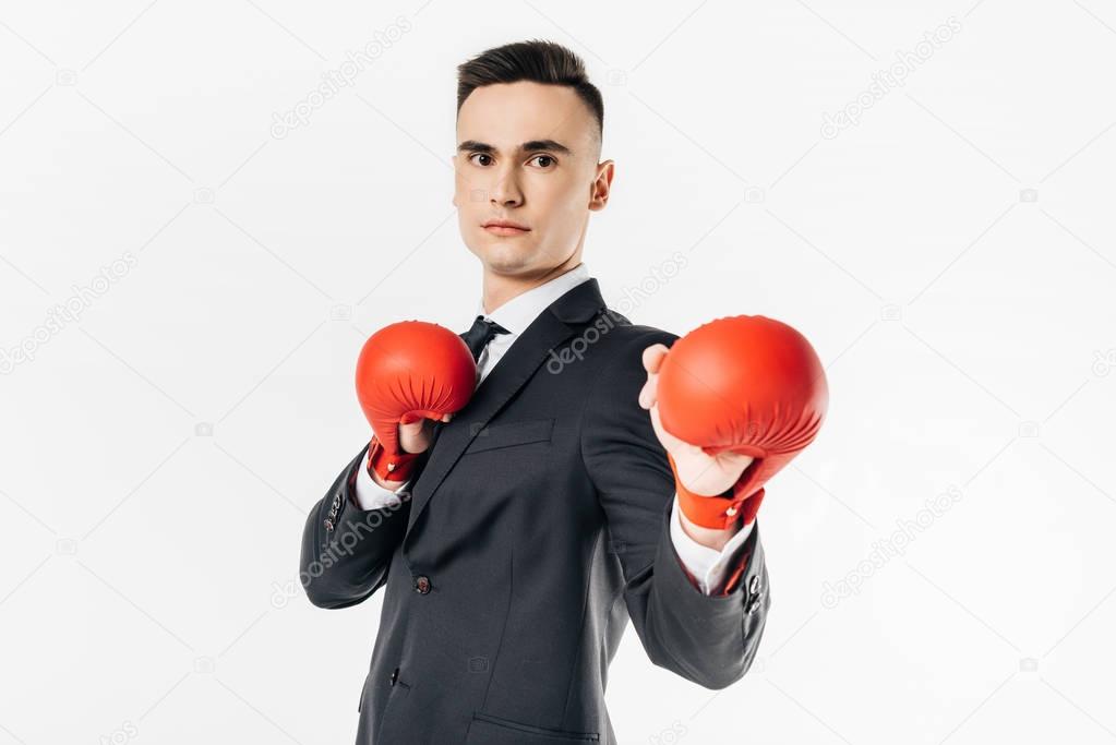 businessman standing in suit and red gloves and looking away isolated on white