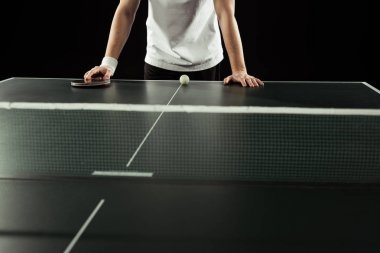 raket ve top siyah izole Tenis masanın üzerine eğilerek tenisçi kırpılmış atış