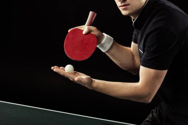 cropped shot of tennis player with tennis ball and racket in hands isolated on black clipart