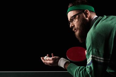 Tenis raketi ve siyahta izole Top sakallı tenisçi yan görünüm