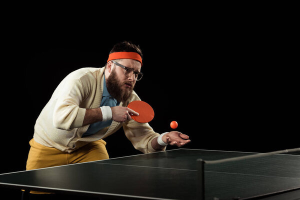 bearded tennis player practicing in tennis isolated on black