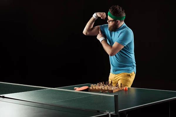 Tennisspieler Zeigt Muskeln Beim Stehen Der Tischtennisplatte Mit Schachbrett Isoliert — Stockfoto