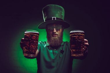 close-up view of bearded man in green irish hat holding glasses of beer  clipart