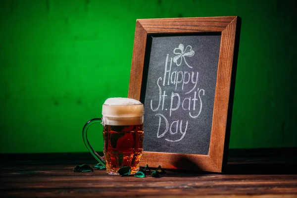 幸せなセントを持つ木造パトリック日碑文とテーブルの上のビールのグラス — ストック写真