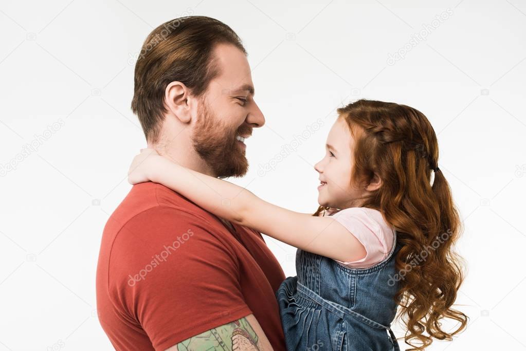 Side view of smiling father and daughter isolated on white