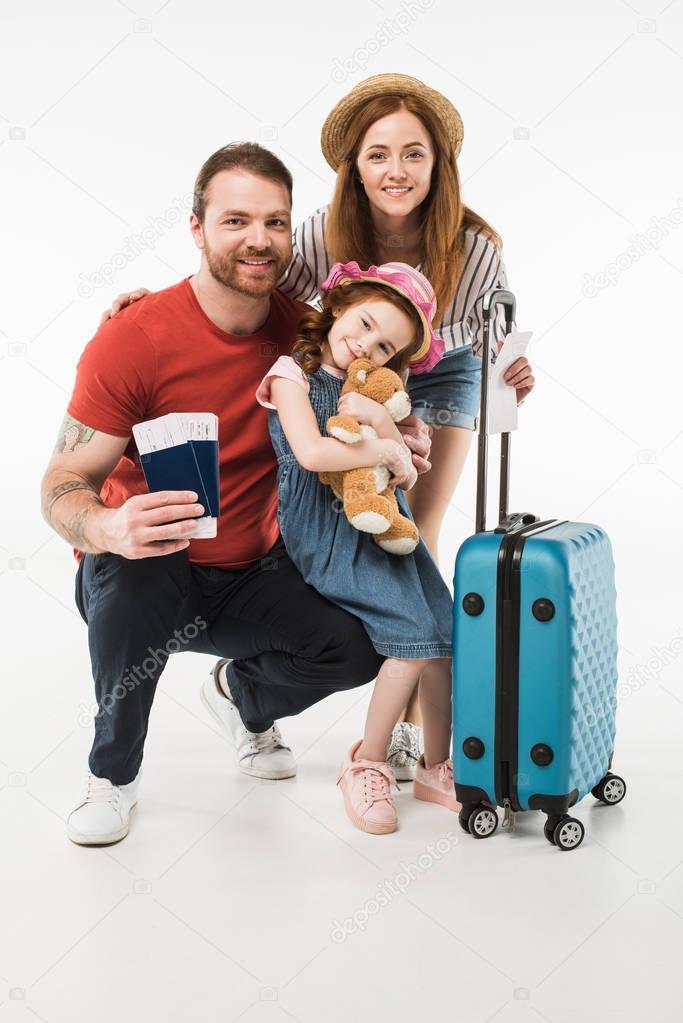 Portrait of happy family of tourists with suitcase isolated on white