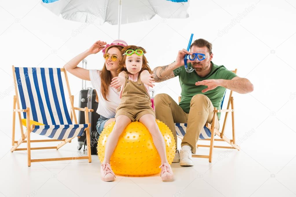 Family in swimming goggles depicting swim with sunshade, sun loungers and ball isolated on white, travel concept