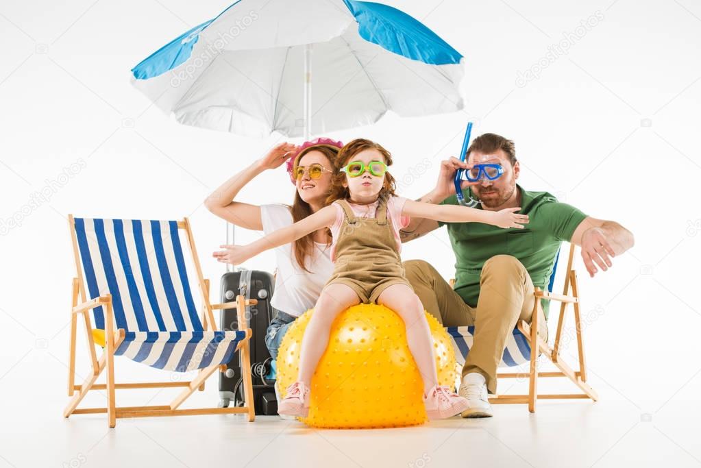 Family in swimming goggles with sunshade, sun loungers and ball isolated on white