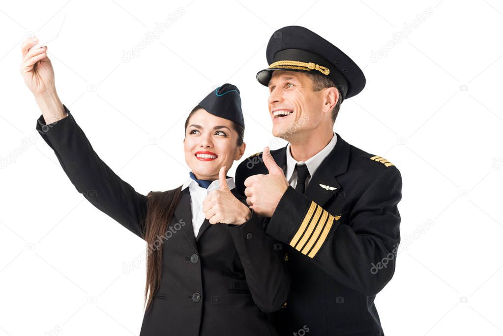 Smiling stewardess and pilot taking selfie isolated on white