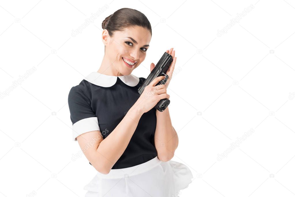 Smiling maid in uniform holding gun isolated on white