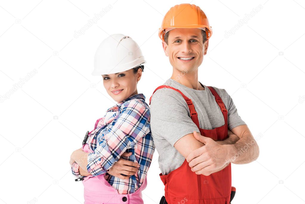 Male and female builders in hardhats and overalls isolated on white