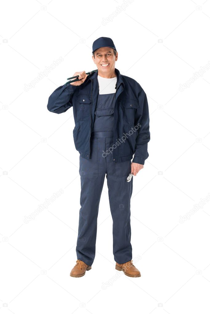 Handsome plumber in overalls holding adjustable wrenches isolated on white
