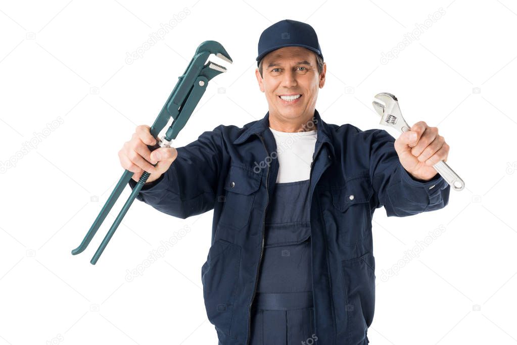 Professional plumber in overalls holding wrenches isolated on white
