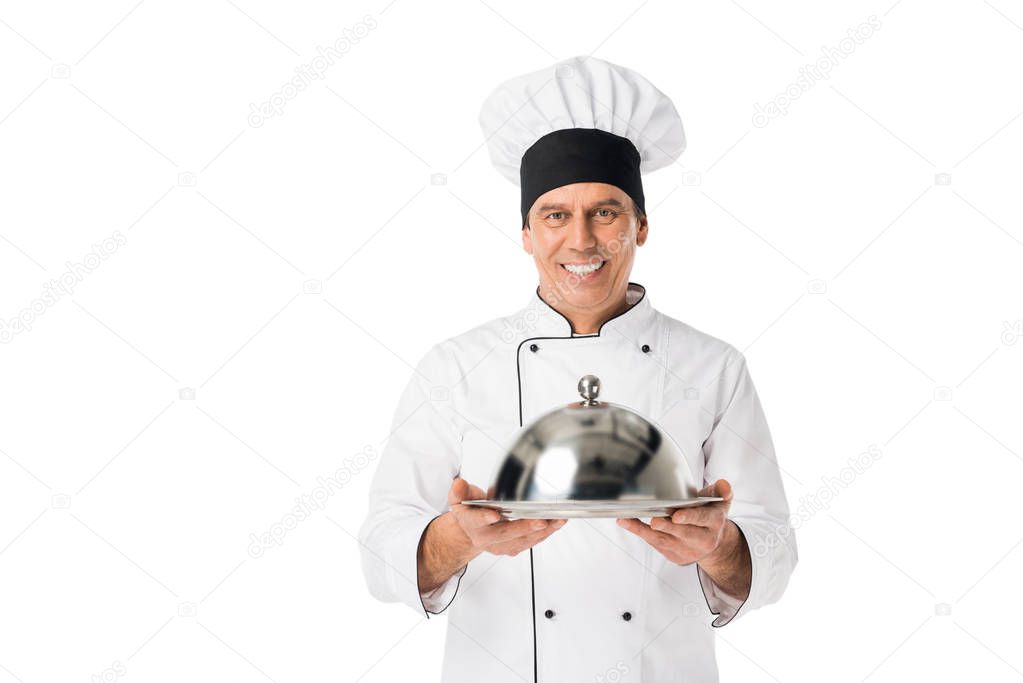 Chef in uniform and toque blanche holding tray with cover isolated on white