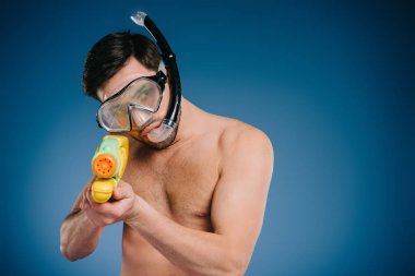 young man in snorkel and diving mask holding water gun on blue  clipart