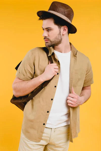 Guapo Barbudo Joven Sombrero Sosteniendo Mochila Mirando Hacia Otro Lado —  Fotos de Stock