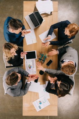 Top view of business colleagues doing construction with pencils at table in office clipart