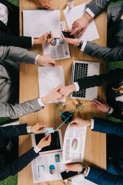 Üstten Görünüm Office masada çalışma arkadaşları ise el sıkışan iki iş ortakları