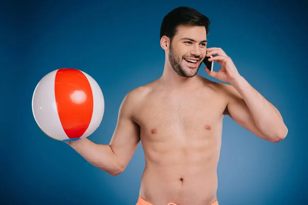 ビーチボールを保持 ブルーでスマート フォンで話す笑顔の若いの上半身裸の男  — 無料ストックフォト