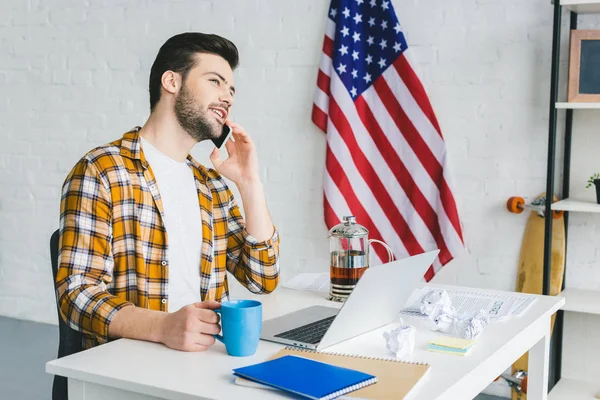 Young Freelancer Drinking Tea Talking Smartphone Light Office — Stock Photo, Image