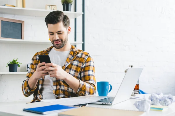 Młody Freelancer Pracuje Przez Stół Pomocą Smartfona Domowym Biurze — Zdjęcie stockowe