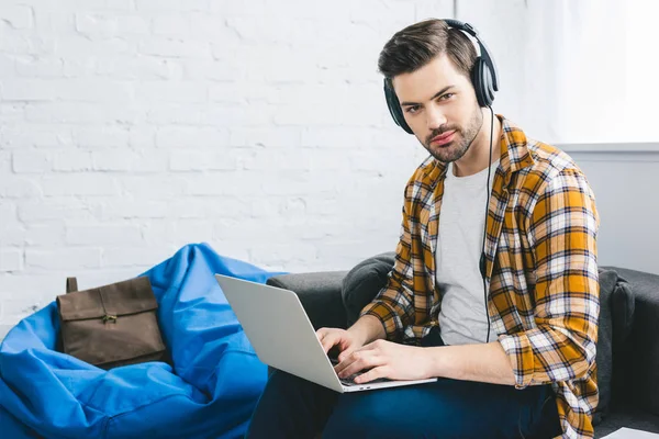 Lächelnder Mann Mit Kopfhörern Arbeitet Laptop Hellen Büro — kostenloses Stockfoto