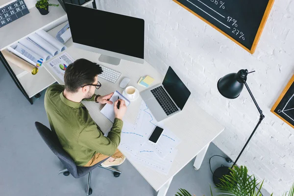 Jeune Homme Regardant Écran Ordinateur Prenant Des Notes Dans Bureau — Photo