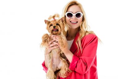 Pembe elbise sevimli köpek üzerinde beyaz izole tutan sarışın kadın