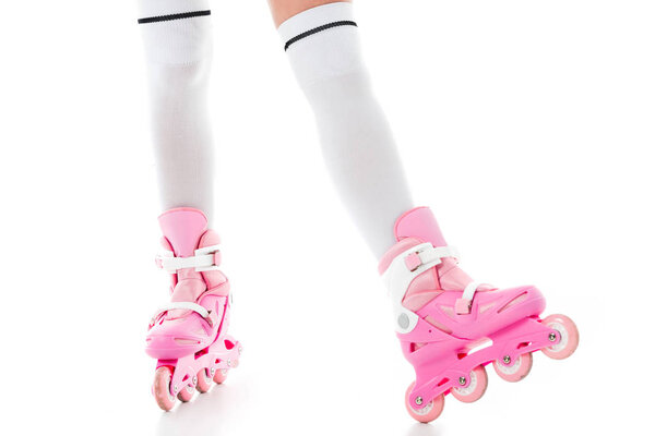 Close-up view of woman in pink inline roller skates isolated on white