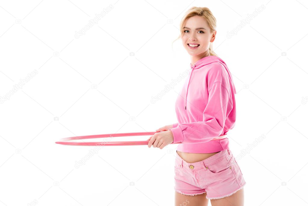 Young girl wearing pink exercising with hula hoop isolated on white