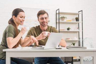 kahve içme ve laptop ile birlikte evde çalışan genç mutlu çift