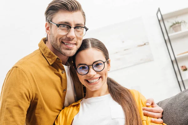 Happy Young Couple Embracing Home Looking Camera — Stock Photo, Image