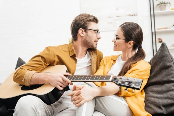 Knappe Jongeman Met Gitaar Flirten Met Vriendin Thuis — Gratis stockfoto