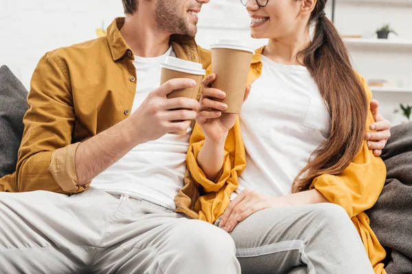 在沙发上拍的情侣调情和无比的咖啡纸杯 — 免费的图库照片