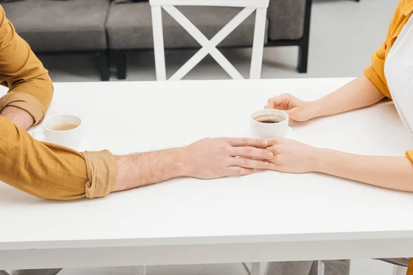Cropped Shot Couple Drinking Coffee Together Holding Hands — Free Stock Photo