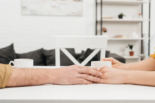 Cropped Shot Couple Drinking Coffee Together Holding Hands Home — Free Stock Photo