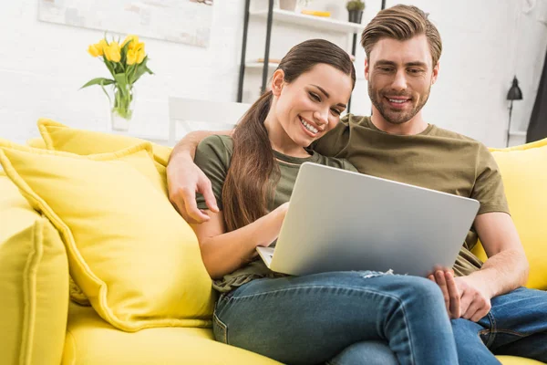 年轻快乐夫妇一起使用笔记本电脑在家里 — 图库照片