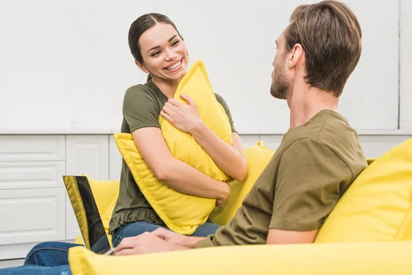 Giovane Donna Abbracciando Cuscino Seduto Fronte Suo Ragazzo Mentre Lavora — Foto stock gratuita