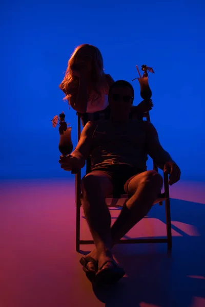 Σιλουέτα Της Γυναίκας Ακουμπά Στην Καρέκλα Άνθρωπο Και Κρατώντας Κοκτέιλ — Δωρεάν Φωτογραφία