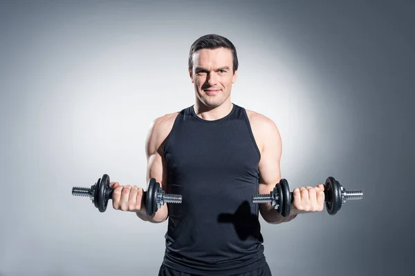 Active Man Lifting Dumbbells Grey Background — Stock Photo, Image