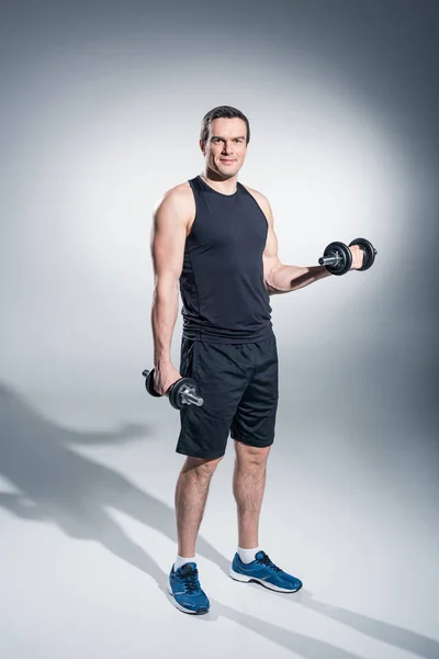 Young Man Athlete Exercising Dumbbells Grey Background — Stock Photo, Image